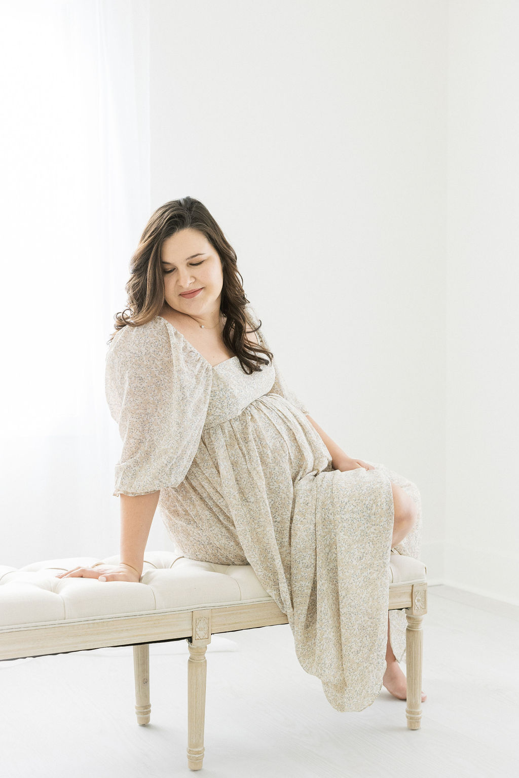 mom to be in cream maternity gown sitting on a bench birth center morristown nj