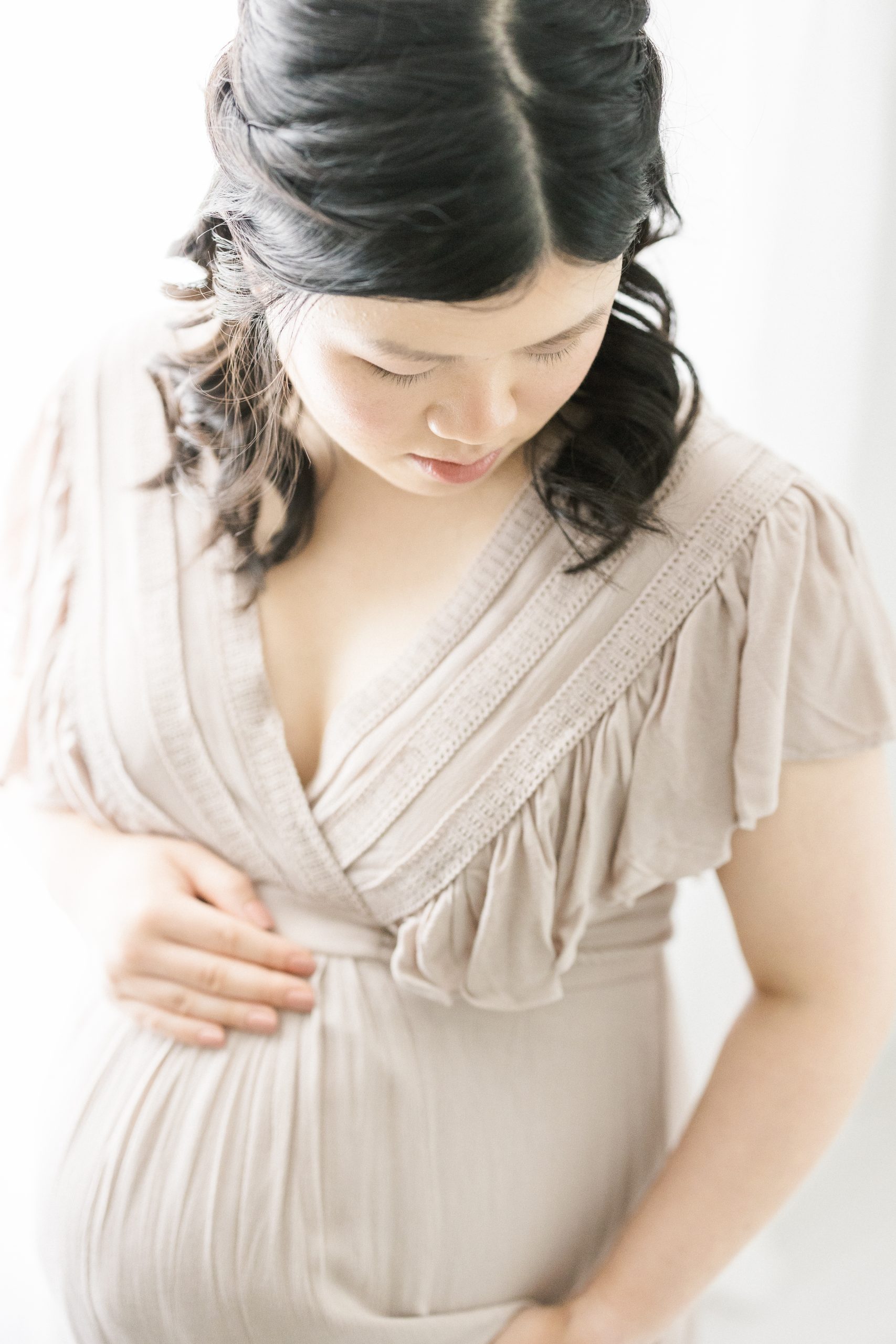 pregnant mom cradling and looking down at her bump by NJ Newborn Photographer