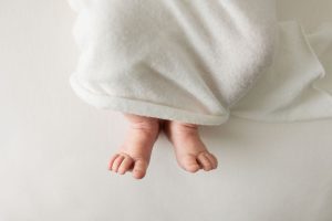 Newborn baby lays in a studio with toes exposed